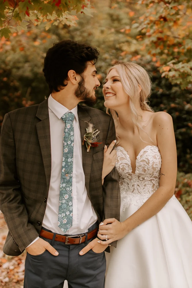 A couple on their wedding day under fall leaves